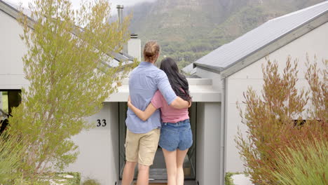 Young happy couple hugging outside their new home