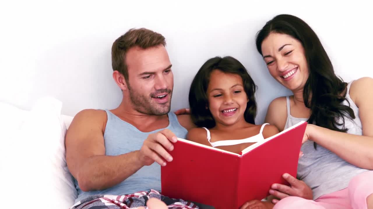 familia leyendo un libro en su linda cama
