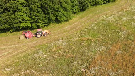 round baler discharge fresh hay bale during agricultural harvesting in leelanau county, michigan