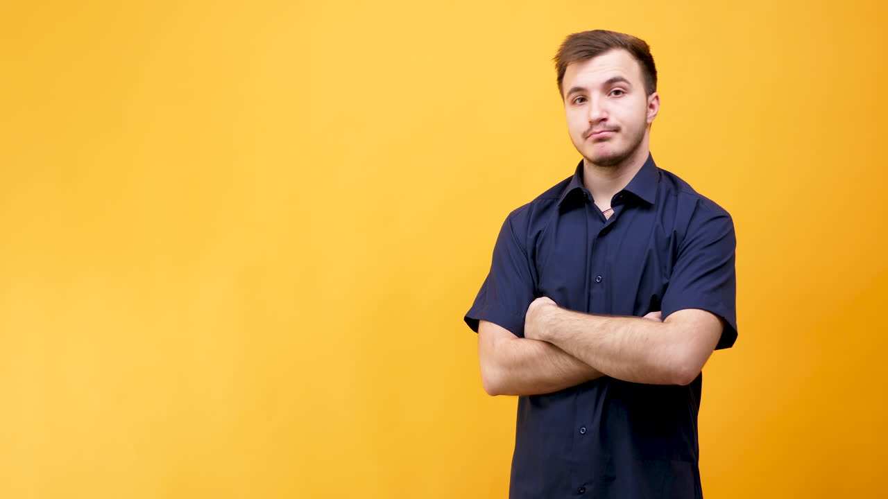 Man in blue shirt with arms folded