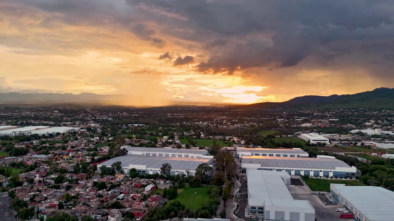 황금 시간 동안 해가 지는 테포츠란 산맥의 하이퍼 스, 주거, 산업 및 자연 지역을 포착하고, 쿠아우티틀란의 아크소틀란 호수에 반사되는 것을 강조합니다.