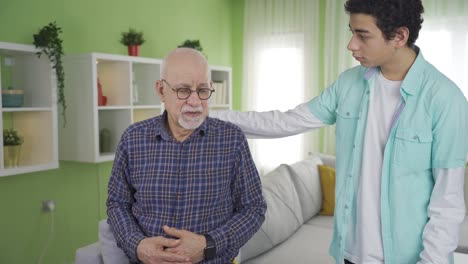 While-the-emotional-grandfather-looks-around,-his-grandson-comes-to-comfort-him.