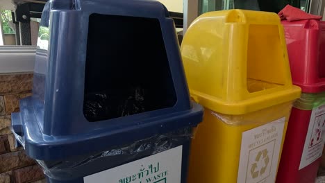 person demonstrating how to use recycling bins.