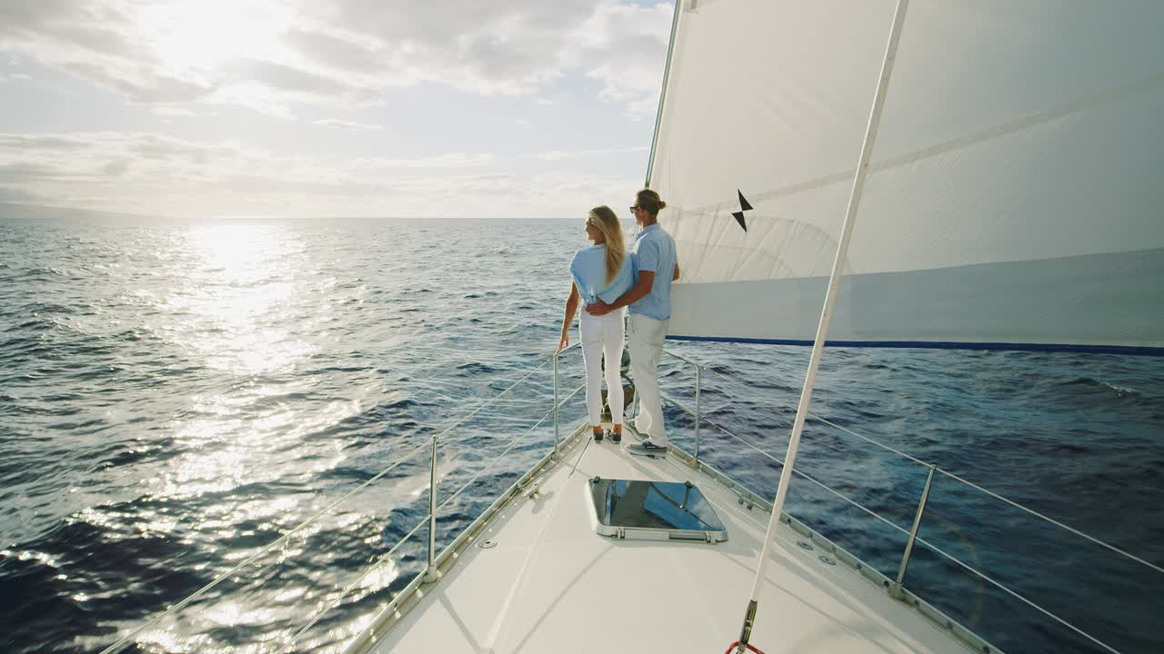 una pareja navegando hacia la puesta de sol.
