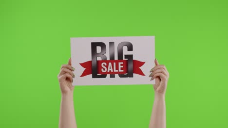 big sale advertisement inscription on paper sheet in womans hands on chroma key. slow motion