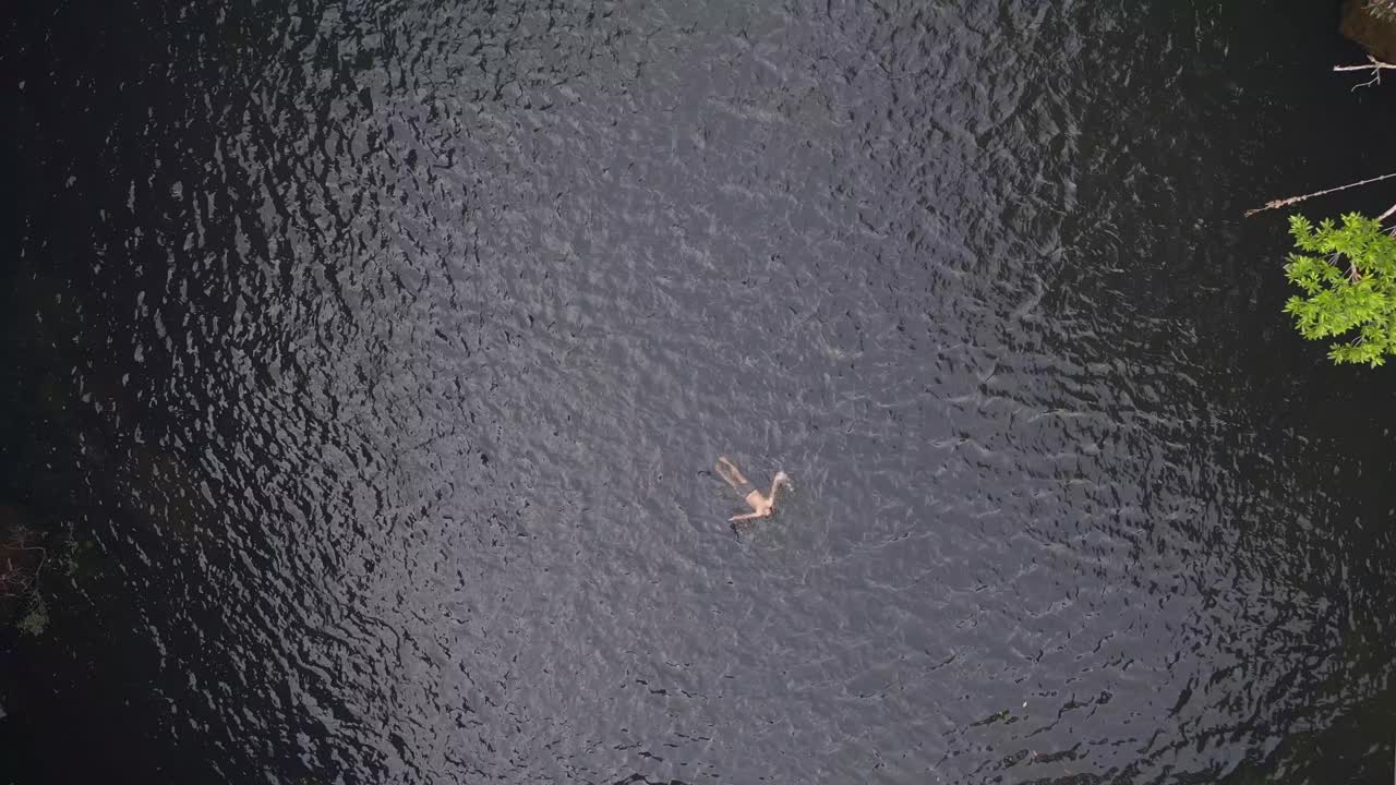 1 millón de $ vista aérea vuelo imágenes de drones hombre nada solo en el lago para cascada río vertical vista de pájaro drone de tailandia selva cascada koh kood, día de diciembre de 2022