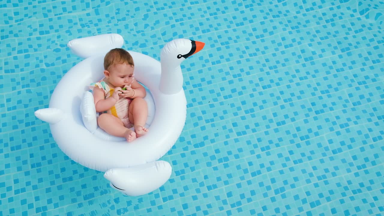 Baby swims in a circle in the pool. Selective focus.