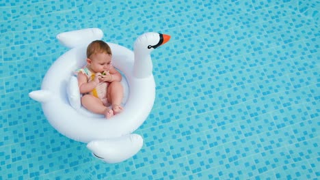 baby swims in a circle in the pool. selective focus.