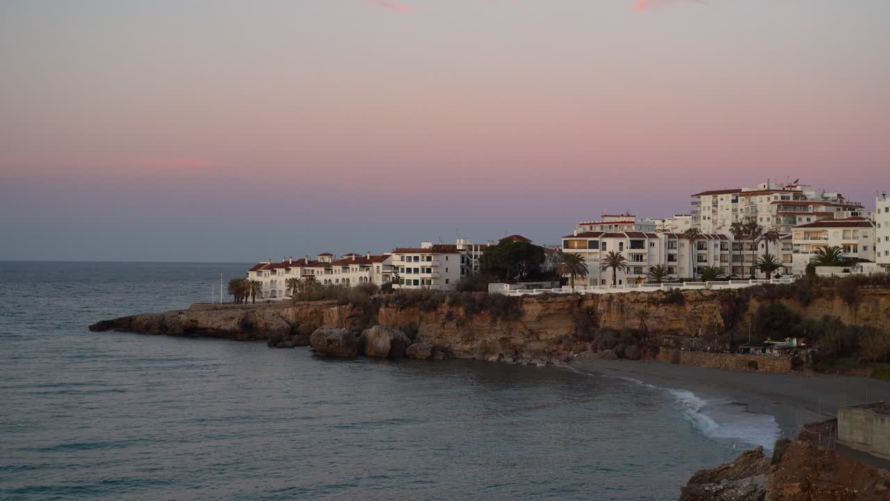 hermosas casas blancas al atardecer rosa junto al mar y la playa