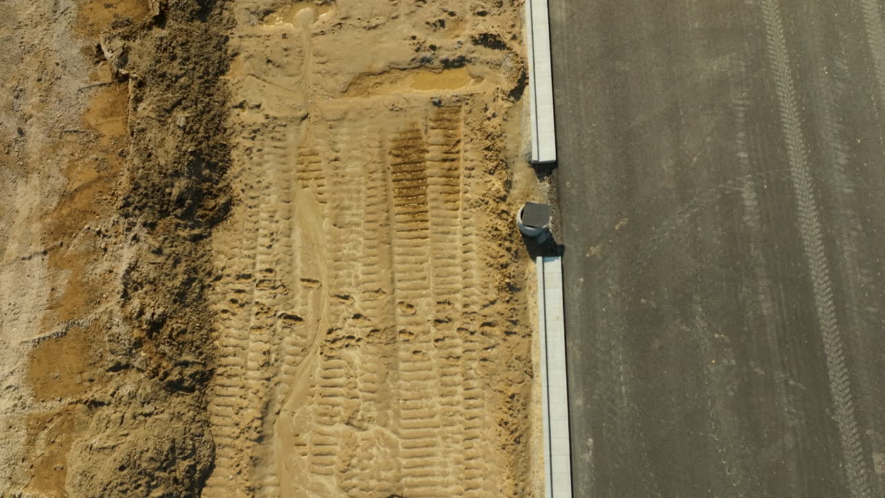 vista detallada de un sitio de construcción de carreteras con huellas de neumáticos en el suelo