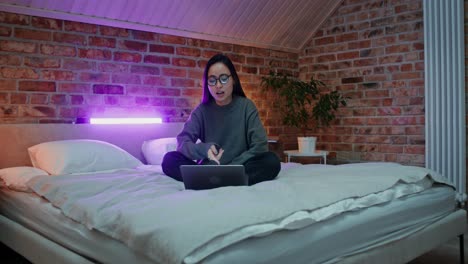 woman having a video call in her bedroom at night.