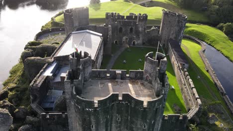 welsh flag waving on gatehouse of caerphilly castle, united kingdom, aerial view