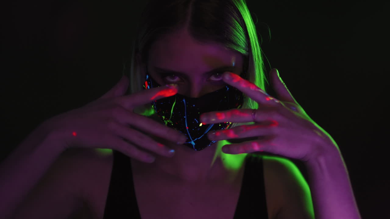 Donna sensuale con maschera viso fluorescente