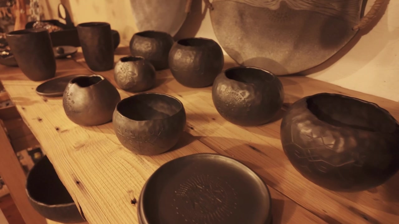 Colección de cerámica negra expuesta en un ambiente acogedor de tienda de cerámica artesanal