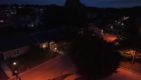 Aerial-flyover-american-neighborhood-with-parking-cars-at-night