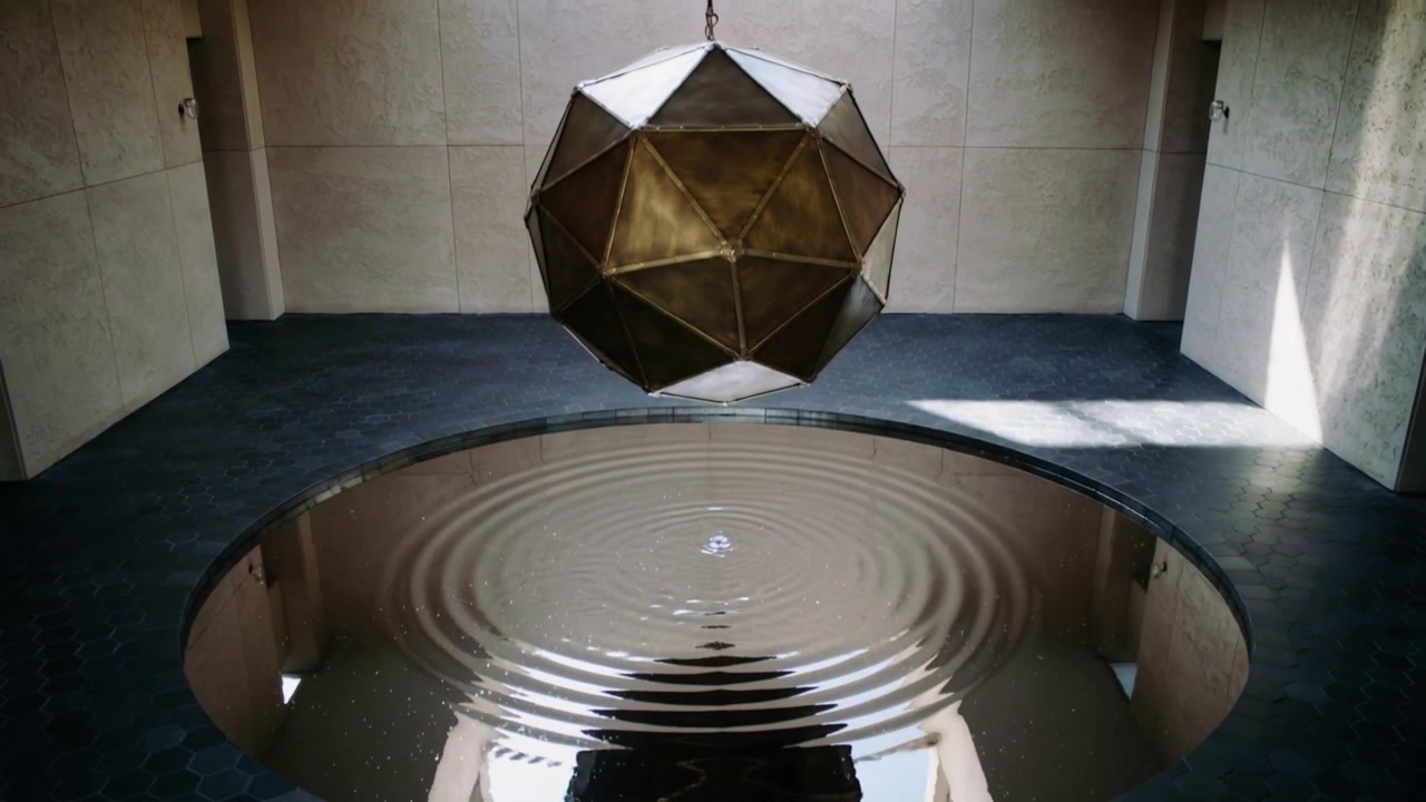 Hanging polyhedron over atrium pool, ripple starting rings growing then decaying