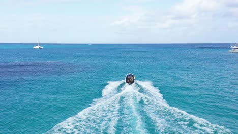 tracking drone shot behind local caribbean boat taking tourists out for diving