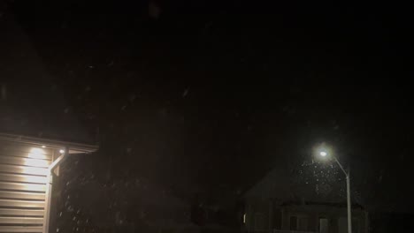 Snowy-night-with-street-light-and-pot-light-on-home