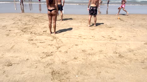 mujer atractiva chica sacudiendo la arena de su nalga traje de baño en la playa en el fondo del mar océano de primer plano