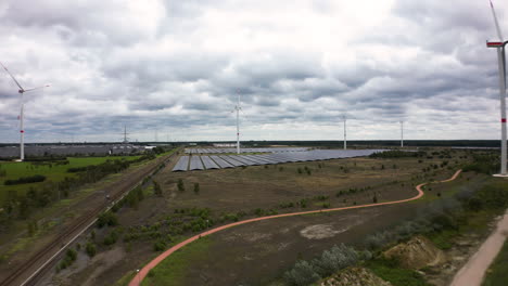 fluffy clouds and wind turbines spinning, aerial ascend view