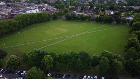 drone flying over large green recreational park in countryside in england