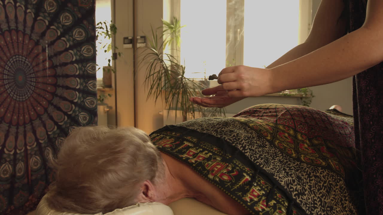 Ritual with incense. Incense, burning incense over the client's lying body. Preparation or completion of a lomi lomi massage in a wellness salon