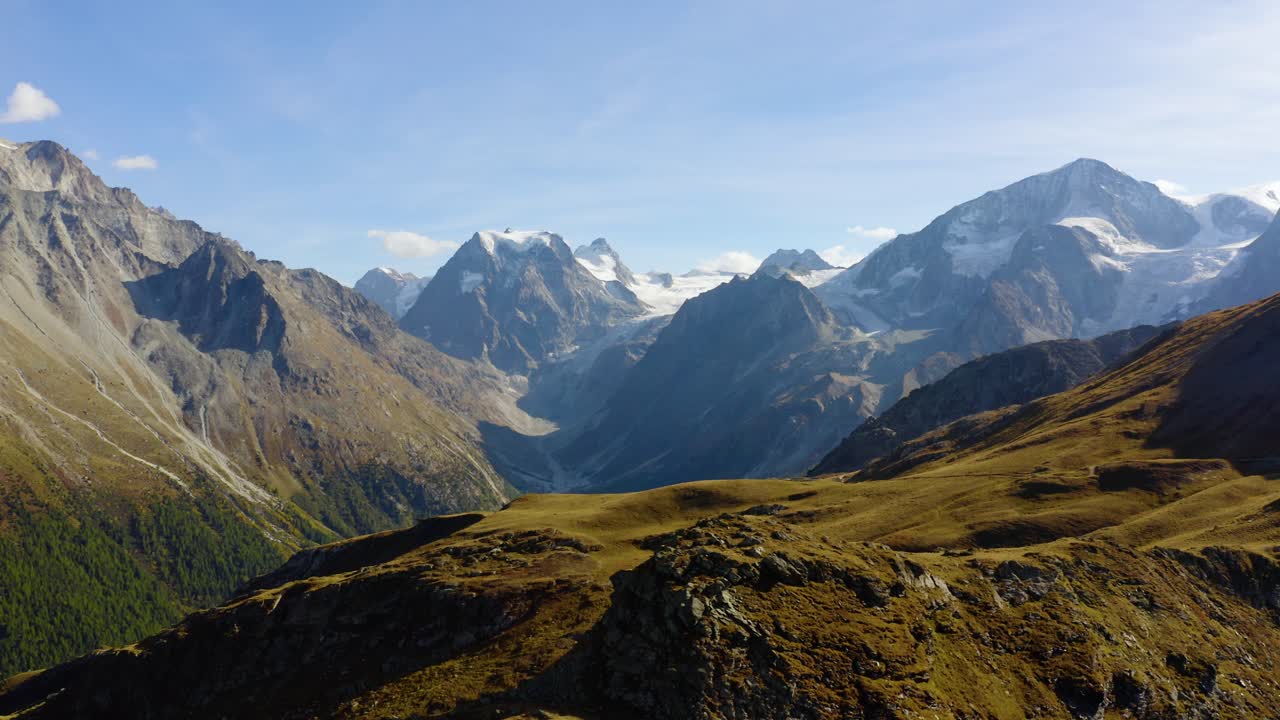 Aerial orbit around mountainous landscape revealing high mountain peaks and glaciers Autumn colors in Arolla, Valais - Switzerland