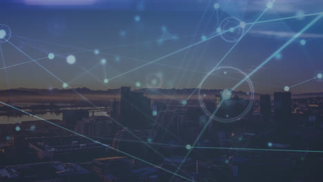 animation of connected dots with lines over aerial view of modern city against mountains and sky