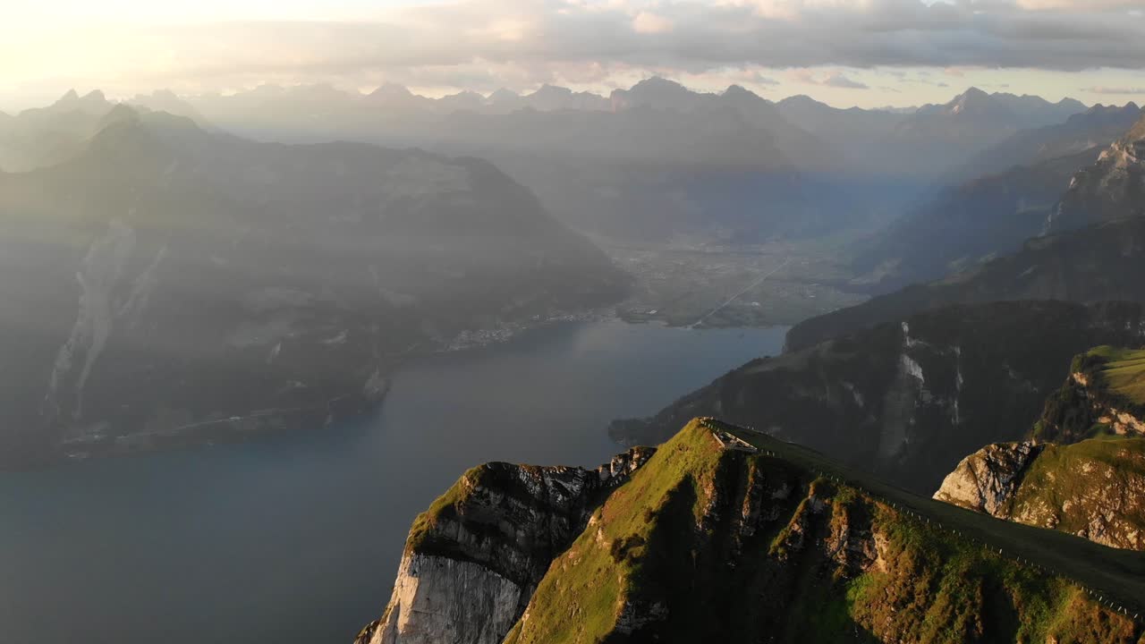 sobrevuelo aéreo junto a los acantilados de niederbauen chulm en uri, suiza, con vistas al lago de lucerna y sus fiordos en una mañana dorada de verano en los alpes suizos