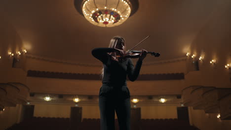 portrait of young woman with violin in opera house fiddler is playing violin in music hall