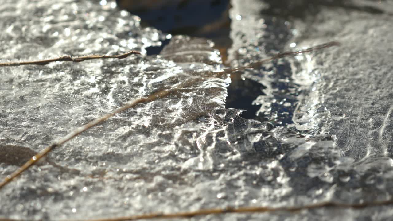 Beauté et danger des couches de glace qui fondent et se fissurent à la surface de l'eau de la rivière