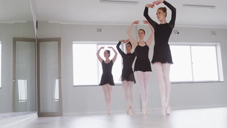 caucasian female ballet dancers practicing a dance routine during a ballet class