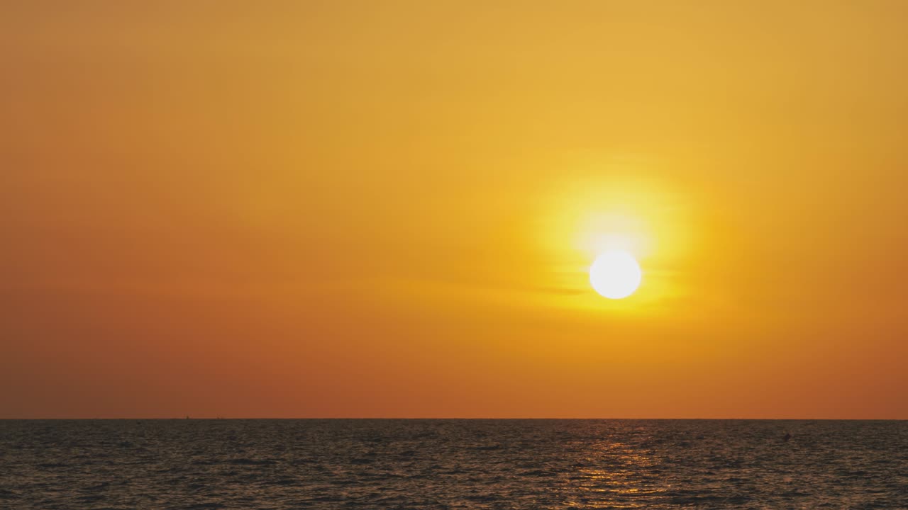 timelapse de una puesta de sol dorada en el extranjero. puesta de sol naranja redonda en el agua en la noche de verano. paisaje naturaleza amanecer fondo. imágenes b rollo de sol. cielo amarillo puesta de sol. hermoso océano tranquilo.