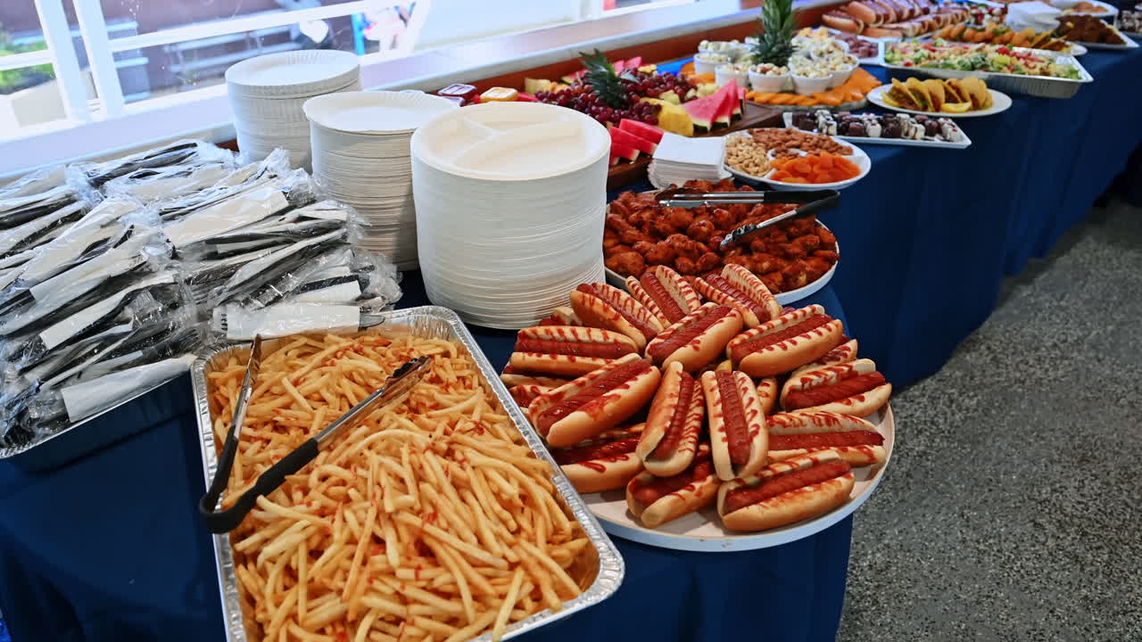 Tavolo da buffet con hot dog, patatine fritte e insalate su una nave da crociera. Primo piano del tavolo da buffet di una nave da crociera con hot dog, patatine fritte e insalate pronti per gli ospiti