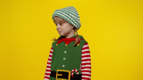 displeased girl in christmas elf santa helper costume looking unhappily angry, sad. negative emotion