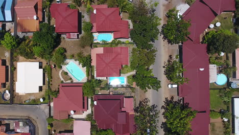 Vertical-drone-shot-of-a-neighbourhood-with-pools-in-Guiana-sunny-day