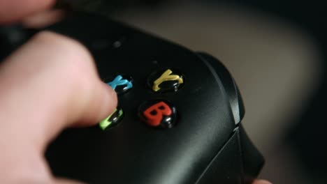 close up of fingers pressing buttons on video game controller