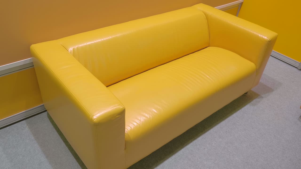 un sofá de cuero amarillo brillante, nuevo, moderno, elegante en una habitación grande