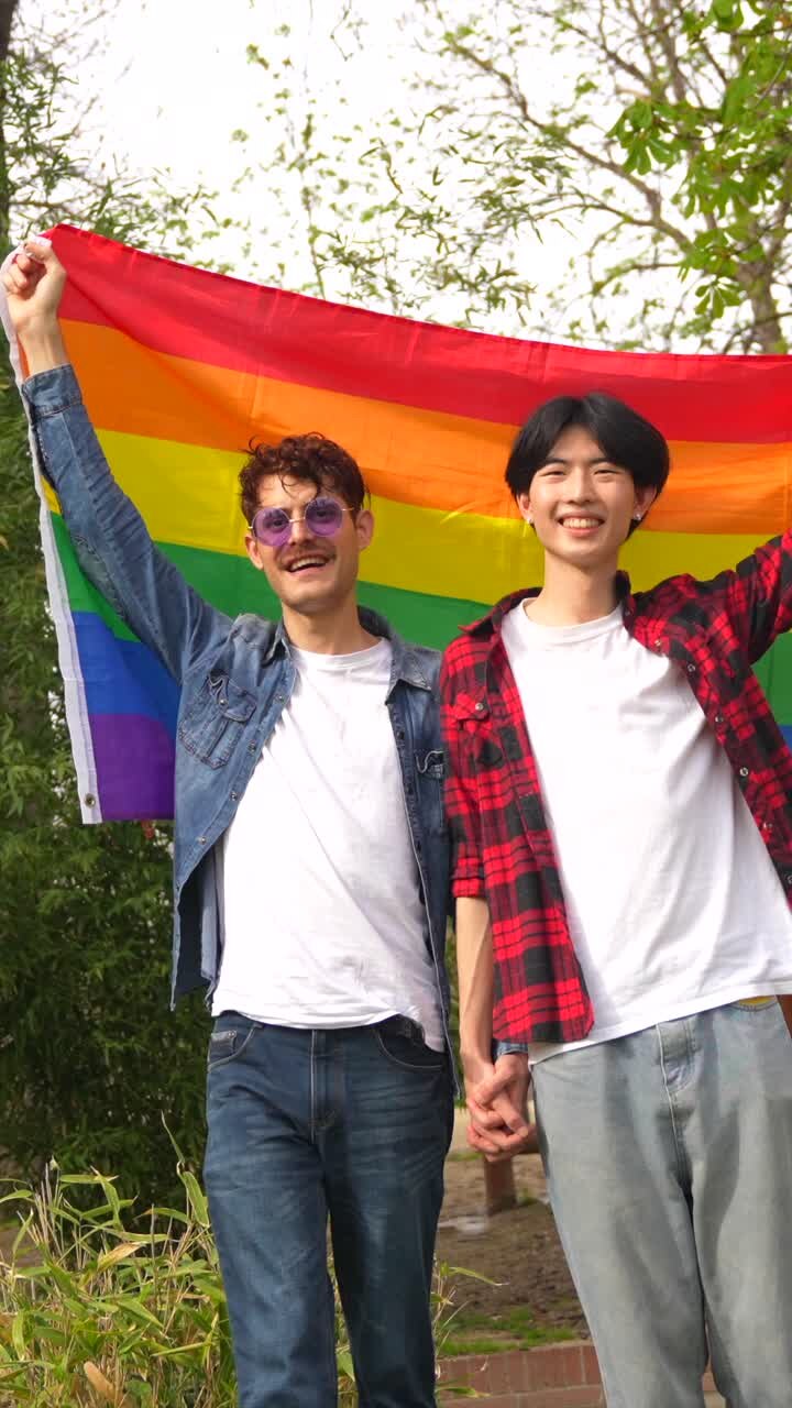 Happy LGBTQ couple celebrating Pride with rainbow flag