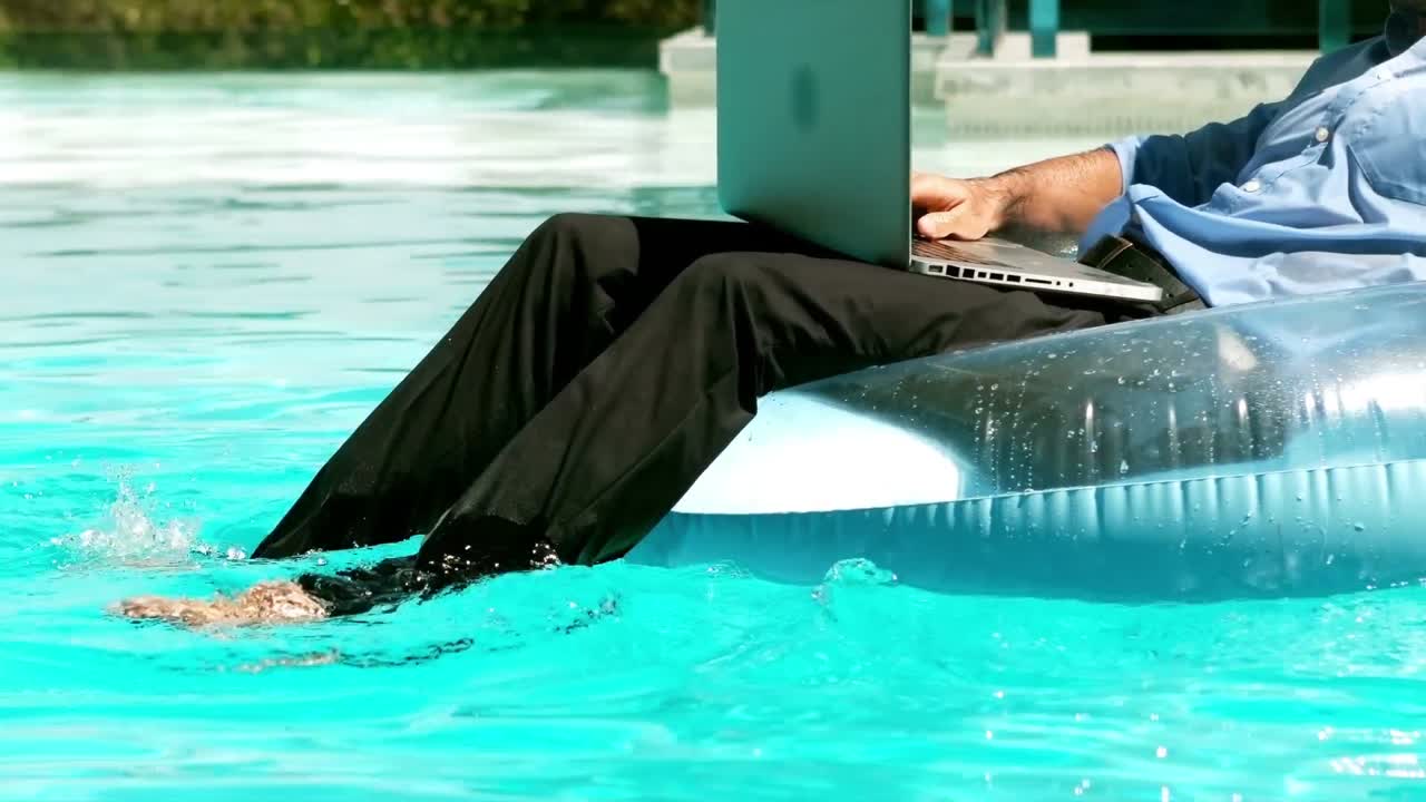 Businessman using his laptop sitting on buoy