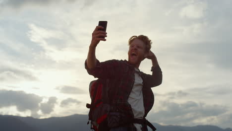 excursionista emocional posando selfie en la cámara del teléfono. hipster de viaje tomar una foto afuera