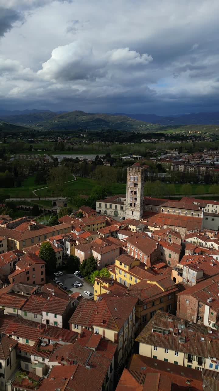Torre delle Ore Clock Tower Lucca medieval city in Italy, aerial drone vertical video