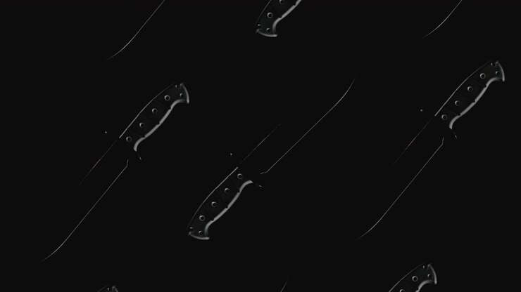 Knives on the dark background and in blinking light rotate in slowmotion