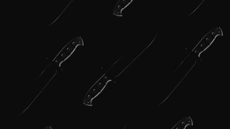 knives on the dark background and in blinking light rotate in slowmotion