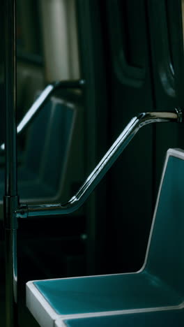 close up of a blue subway seat and chrome handrail