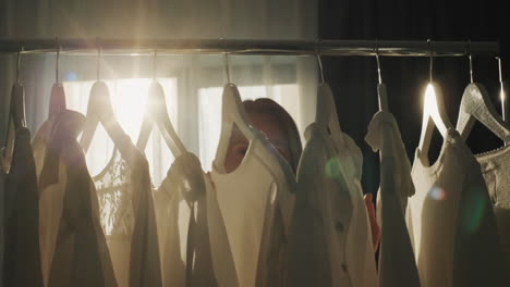 A-woman-chooses-clothes-in-the-dressing-room.-Silhouette-in-the-sun