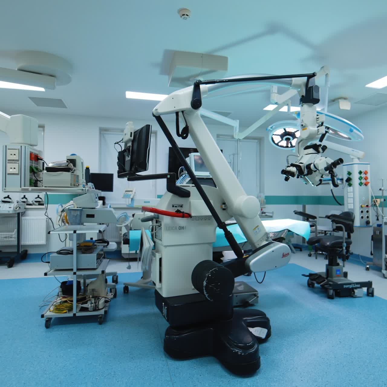 Door opening in the preoperational room to a modern spacious surgery room. Diverse neurosurgical equipment is in the operational theatre