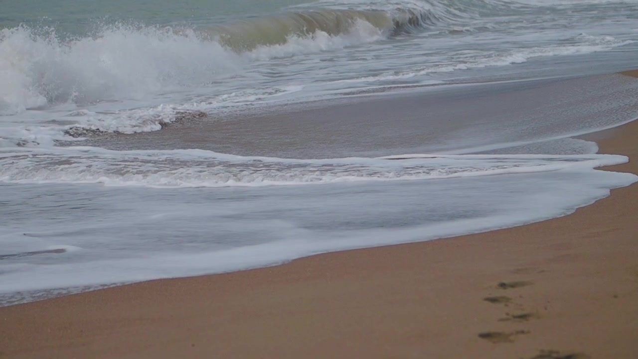 Le dolci onde dell'oceano si muovono sulla spiaggia sabbiosa