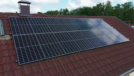 drone orbit reveals a large photovoltaic array mounted on a terracotta tile roof, symbolizing clean power and household sustainability under sunny skies