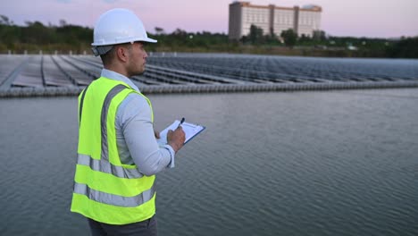 ingeniero asiático trabajando en una granja solar flotante